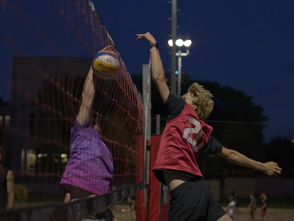 Un bloc au filet pendant un match de volleyball de plage au Cinq à Sweat