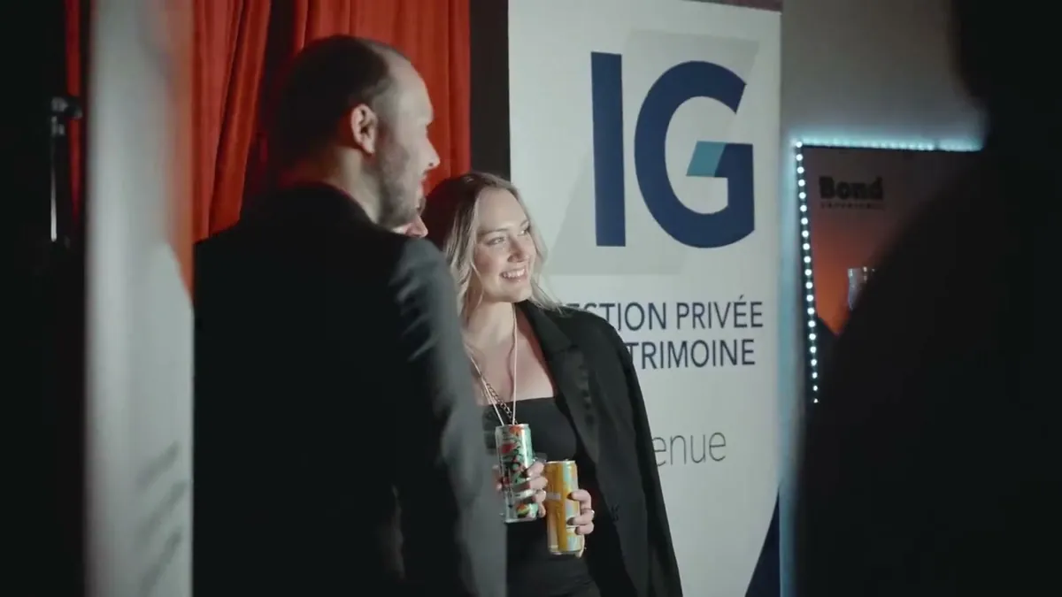 Deux invités devant la bannière d'IG Gestion de patrimoine au Grand Souper Entrepreneurial